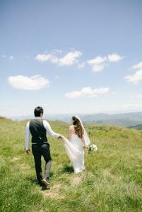 A groom carrying a bride's dress at Max Patch